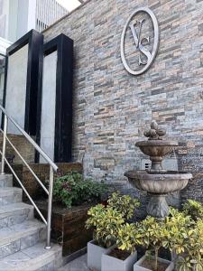 a brick wall with a fountain and a clock on it at Hotel Vila Santa in Lima