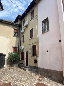 ein weißes Gebäude mit Fenstern und einem Steinhof in der Unterkunft Hailey House in Cavalcaselle