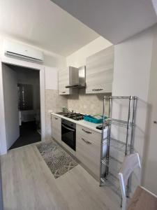 eine Küche mit weißen Schränken und einem Herd mit Backofen in der Unterkunft Hailey House in Cavalcaselle