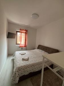 ein kleines Schlafzimmer mit einem Bett und einem Tisch in der Unterkunft Hailey House in Cavalcaselle