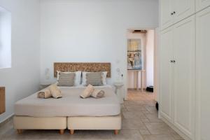 a white bedroom with a large bed with two pillows at Casa Elia in Sarakíniko