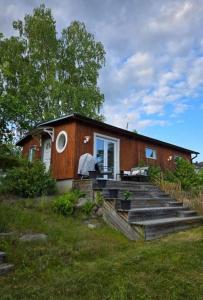 a small house with a porch and stairs to it at Gäststugan in Åkersberga