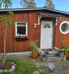a small house with a white door and a window at Gäststugan in Åkersberga