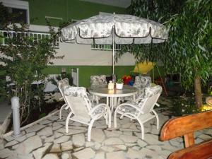 a table and chairs with an umbrella on a patio at Phoenix Studios in Sarti