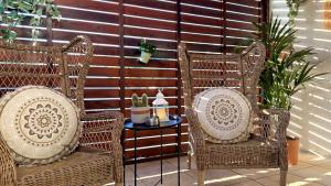 two wicker chairs and a table on a patio at Arithea Hidden Seaside Heritage 2BR Suite in Paphos