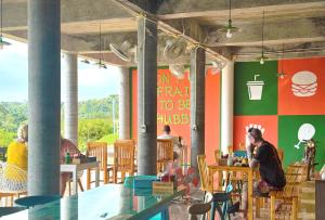 a group of people sitting at tables in a restaurant at Lanta Halabala Resort in Ko Lanta