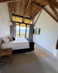 a bedroom with a large bed in a room with windows at Selva Serena in Anapoima