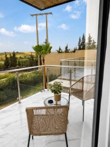 a patio with two chairs and a table on a balcony at Villa Oumnass, Marrakech in Oumnas