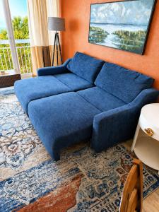 a blue couch in a living room with an orange wall at Renovated Oceanfront 1BR by Skywheel Yachtsman 400 in Myrtle Beach +59 photos