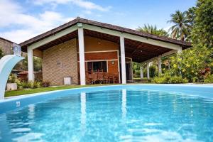 a swimming pool in front of a house at Chácara Paraíso do Mar - Araçagi in São José de Ribamar