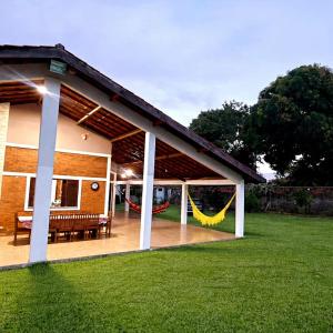 a house with a patio with a hammock on it at Chácara Paraíso do Mar - Araçagi in São José de Ribamar