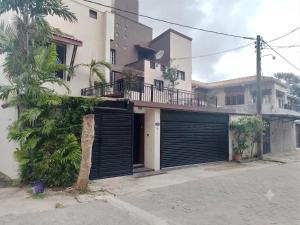 a house with black garage doors on a street at Casa Solare in Wellawatta