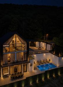 a house with a swimming pool at night at Quba QubaLand in Qǝlǝduz