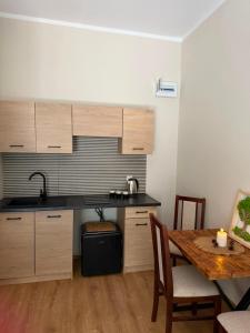 a kitchen with wooden cabinets and a table with a tableablish at Leśna Przystań in Pojezierze