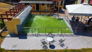 a pool of green water with a slide at Hotel Kastri in Loutra Edipsou