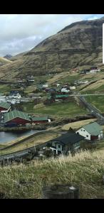a small town in a field with a hill at Central apartment in Vestmanna in Vestmanna