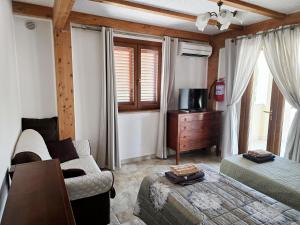 a bedroom with a couch and a bed and a tv at Pizzica Agriturismo in Metaponto