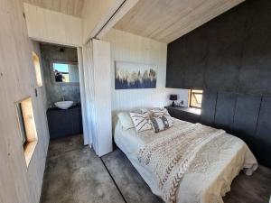 a bedroom with a large bed and a sink at Spectacular tiny house in an unforgettable setting in Ñilque