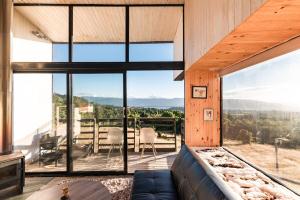 a room with a large window with a couch at Spectacular tiny house in an unforgettable setting in Ñilque