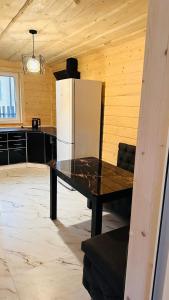 a kitchen with a black table and a refrigerator at Едем 2 in Verkhovyna