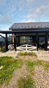 a house with a black roof and a patio at Едем 2 in Verkhovyna