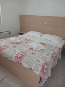 a bed with a blanket and pillows on it at Apartments Maja in Hvar