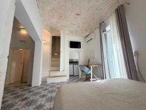 a bedroom with a bed and a desk and a window at Casa Ulivo in Ostuni