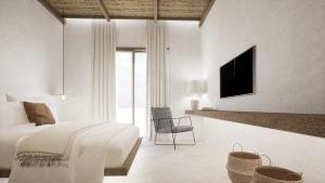 a white bedroom with a bed and a tv at Malie Suites in Mikri Vigla