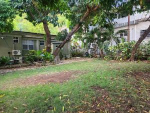 a yard in front of a house with trees at Wilche Cottage in Road Town