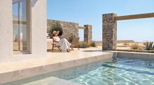 a woman sitting in a chair next to a swimming pool at Malie Suites in Mikri Vigla