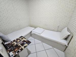 a small room with two beds and a brick wall at Shinam hostel 777 in Chilanzar