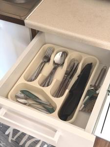 a drawer in a kitchen with utensils in it at Barnaba Domki in Pobierowo
