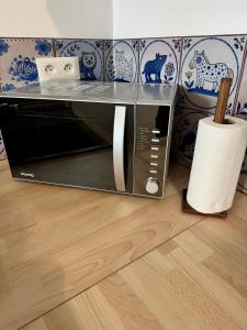 a microwave oven sitting on top of a wooden floor at Le clos Ghisline in Madré