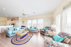 a living room with two couches and a table at Charming ocean-view gem with a pool deck washer dryer & central AC in St. George Island