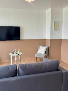 a living room with a couch and a table at Le clos Ghisline in Madré