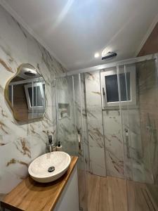 a bathroom with a sink and a shower at Aelio apartment in Ermoupoli
