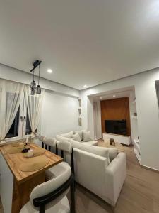 a living room with couches and a table and a television at Aelio apartment in Ermoupoli +2 photos