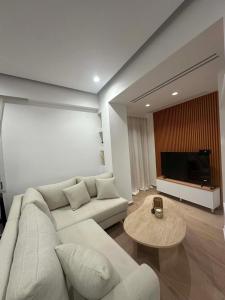 a living room with a white couch and a table at Aelio apartment in Ermoupoli