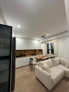 a living room with a white couch and a kitchen at Aelio apartment in Ermoupoli