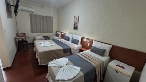 ein Hotelzimmer mit drei Betten in einem Zimmer in der Unterkunft Hotel Rafeli in Boituva + 52 Fotos