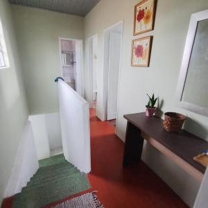 a hallway with a staircase and a table and a room at Sobrado de esquina in Pelotas +26 photos