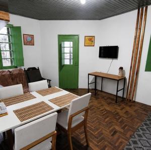a living room with a table and a green door at Sobrado de esquina in Pelotas