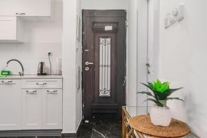 a kitchen with a black door and a table with a plant at חופשה בממלכה in Ashkelon