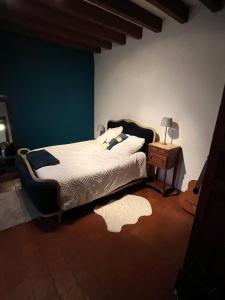 a bedroom with a bed and a table with a lamp at Maison solognotte in Sainte-Montaine