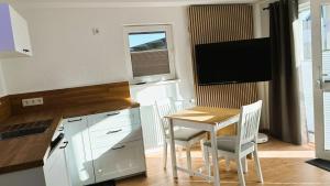a kitchen with a table and chairs and a television at Ferienwohnung Hortwald am Schaumberg in Tholey