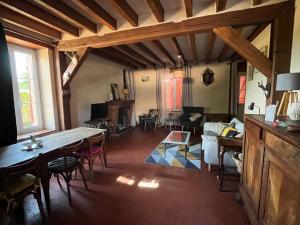 a large living room with a table and a couch at Maison solognotte in Sainte-Montaine