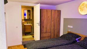 a bedroom with a bed and a door to a bathroom at Ferienwohnung Hortwald am Schaumberg in Tholey