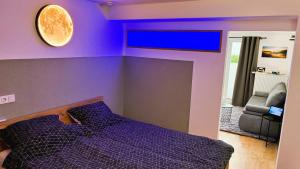 a purple bedroom with a bed and a tv at Ferienwohnung Hortwald am Schaumberg in Tholey