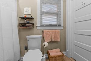 a bathroom with a toilet and a window and towels at Quiet 2BR Near Mercy Dog Friendly, Week & MO Rates in Springfield +79 photos
