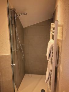 ein Badezimmer mit einer Dusche und Handtüchern auf einem Kleiderständer in der Unterkunft Road Stop Wuppertal in Wuppertal